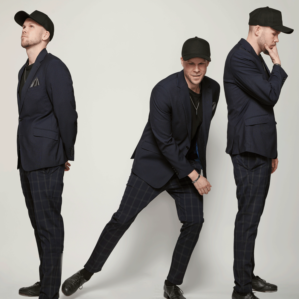 A triptych of Danny Nielsen posing in various poses. He is wearing a black suit and black baseball hat in all three poses.